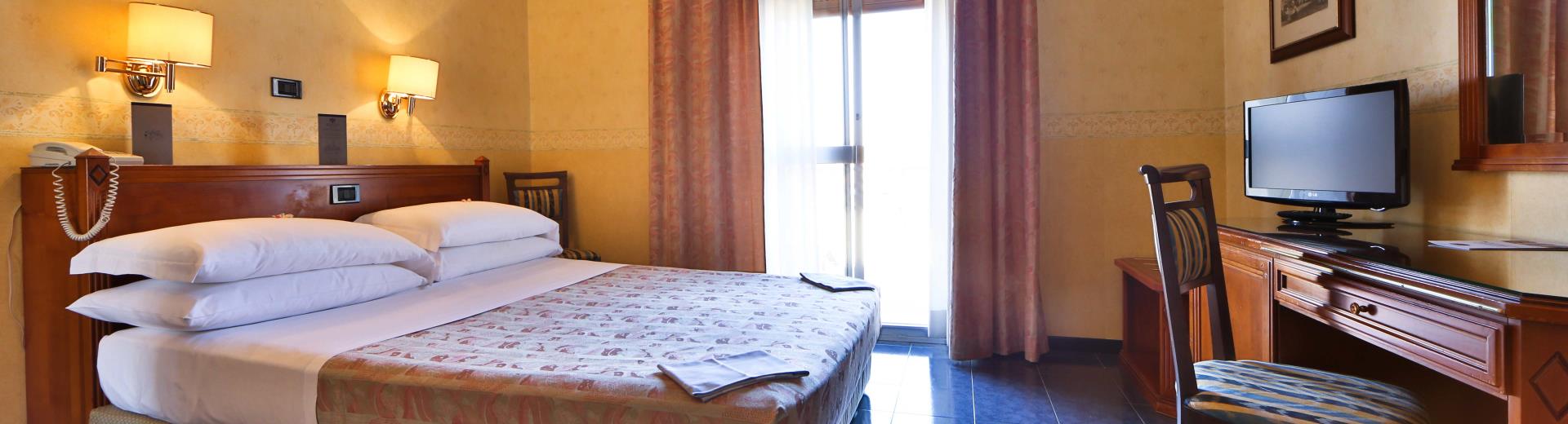Camere Classic comode e funzionali con letto matrimoniale queen size.